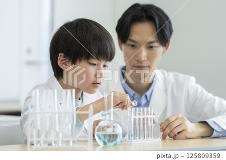 実験をする小学4年生の男の子と先生 125809359
