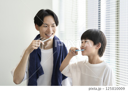歯磨きをする親子　30代の父親と9歳の男の子 125810009