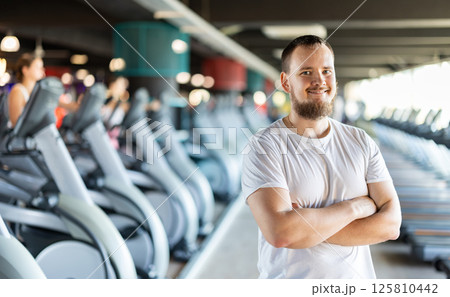 Young man posing by exercise bike 125810442