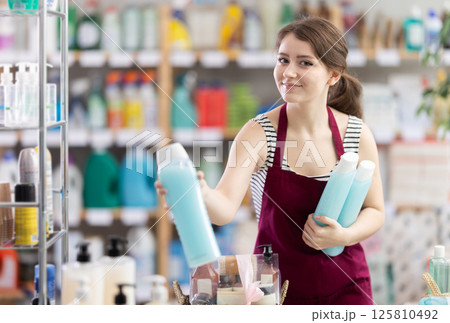 Girl store employee working in sales area designs store window Girl store employee working in sales area designs store window 125810492