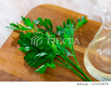 Fresh parsley aromatic herbs on kitchen table 125810639