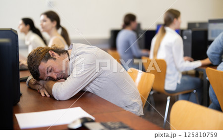 Adult man fell asleep at table in office 125810759