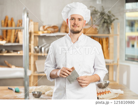 Portrait of professional male baker in uniform in bakery 125810980
