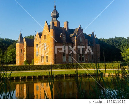 Medieval castle in Flemish town of Rumbeke reflecting in water of pond Medieval castle in Flemish town of Rumbeke reflecting in water of pond 125811015