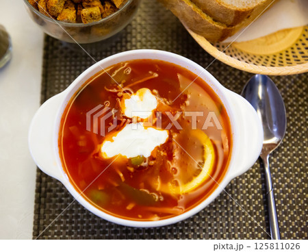 Russian meat soup solyanka with assorted meat and sausages and vegetables Russian meat soup solyanka with assorted meat and sausages and vegetables 125811026