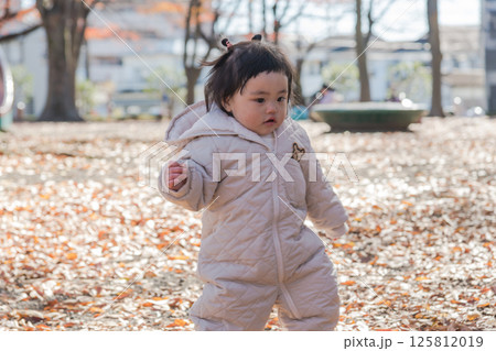 【冬の落ち葉がある公園で遊ぶ1歳児 立つ】 【冬の落ち葉がある公園で遊ぶ1歳児 立つ】 125812019