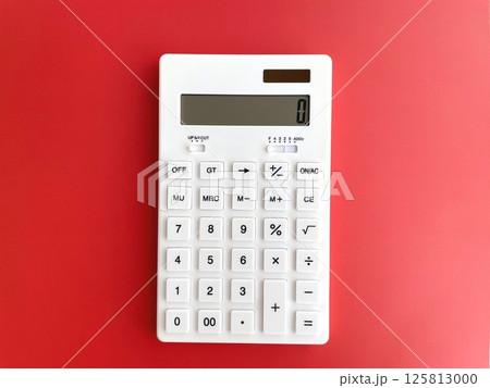 赤背景に置いた白い電卓 赤背景に置いた白い電卓 125813000