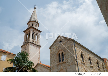 Budva, Montenegro picturesque old town and fortress walls architecture. Stunning showcasing historic stone buildings with red-tiled roofs traditional house. Spire of the chapel of The Church of Sveti Budva, Montenegro picturesque old town and fortress walls architecture. Stunning showcasing historic stone buildings with red-tiled roofs traditional house. Spire of the chapel of The Church of Sveti 125813506