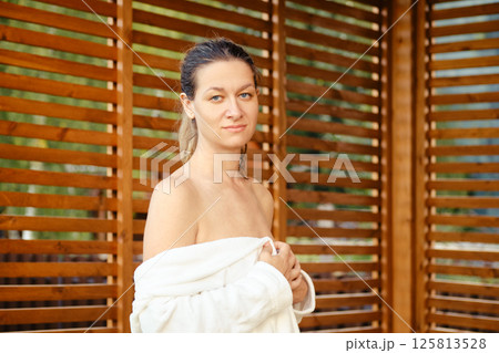 An image of a woman in a bathrobe with a calm expression 125813528