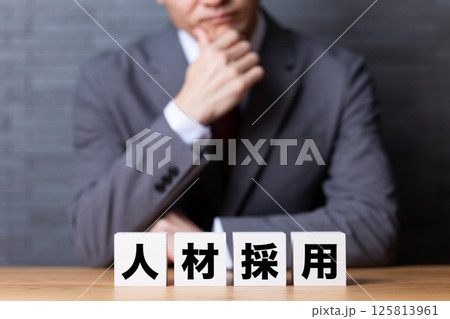 人材採用のブロックとスーツを着て悩むミドル男性ビジネスマン 人材採用のブロックとスーツを着て悩むミドル男性ビジネスマン 125813961