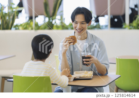 フードコードで食事をする親子 30代の父親と小学生の男の子 フードコードで食事をする親子 30代の父親と小学生の男の子 125814614