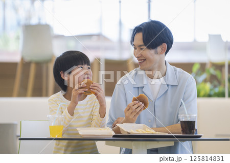 フードコードで食事をする親子 9歳の男の子と30代の父親 フードコードで食事をする親子 9歳の男の子と30代の父親 125814831