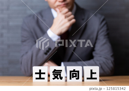 士気向上のブロックとスーツを着て悩むミドル男性ビジネスマン 士気向上のブロックとスーツを着て悩むミドル男性ビジネスマン 125815342