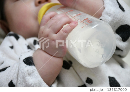 自分でミルクを哺乳瓶で飲む赤ちゃん 125817000