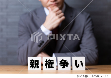 親権争いのブロックとスーツを着て悩むミドル男性ビジネスマン 親権争いのブロックとスーツを着て悩むミドル男性ビジネスマン 125817057