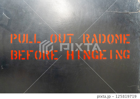 Aircraft fuselage warning message with red stencil lettering Aircraft fuselage warning message with red stencil lettering 125819719