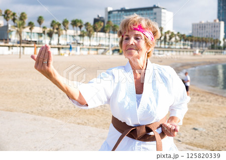 Old woman in kimono on beach Old woman in kimono on beach 125820339