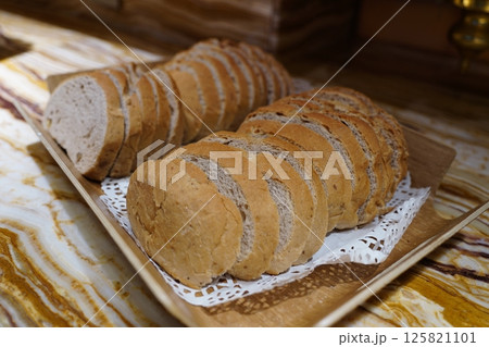 Slices of bread on a wooden plate, close-up 125821101