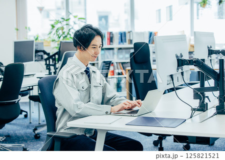 会社で働く作業着の若い男性 125821521