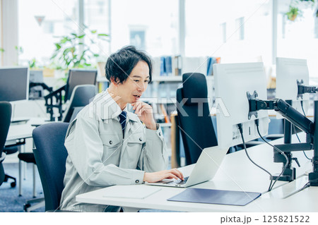 会社で働く作業着の若い男性 125821522