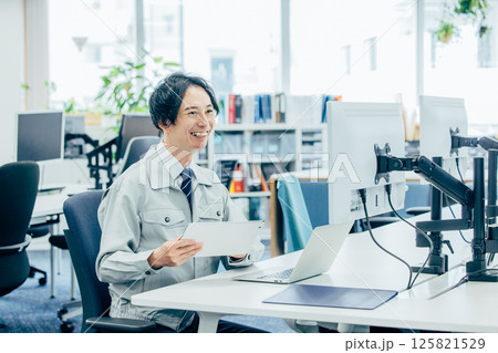 会社で働く作業着の若い男性 125821529