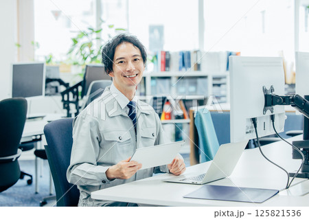 会社で働く作業着の若い男性 125821536