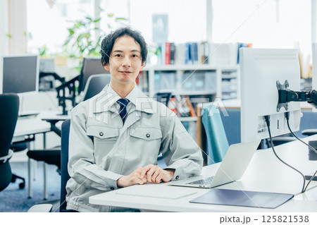 会社で働く作業着の若い男性 125821538