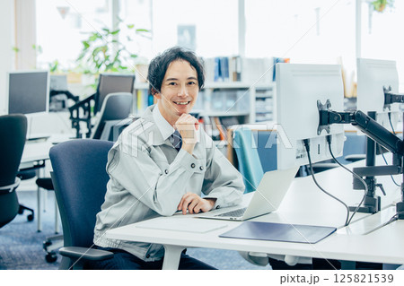 会社で働く作業着の若い男性 125821539