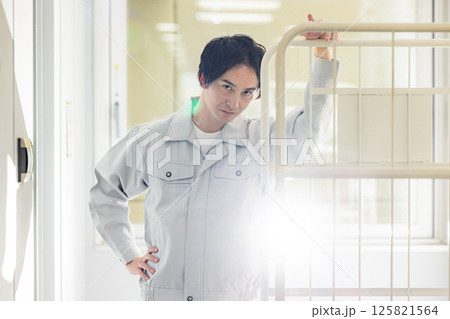 コンテナを運ぶ作業着を着た男性 コンテナを運ぶ作業着を着た男性 125821564