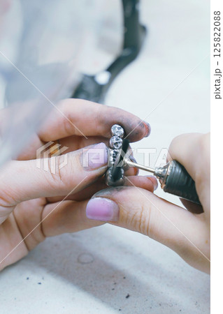 Crafting precise metal dentures by skilled dental technician in workshop Crafting precise metal dentures by skilled dental technician in workshop 125822088