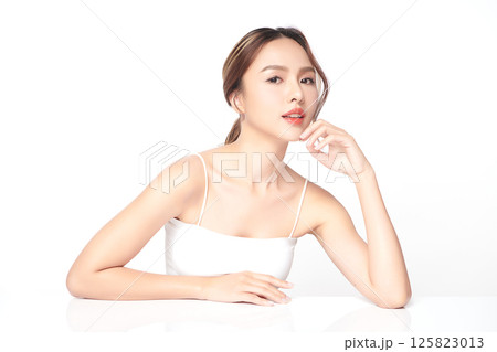 A beautiful young Asian woman with clean, fresh skin against a white background. Skincare, facial treatment, cosmetology, beauty, and spa. An elegant portrait of an Asian woman. 125823013