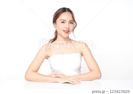 A beautiful young Asian woman with clean, fresh skin against a white background. Skincare, facial treatment, cosmetology, beauty, and spa. An elegant portrait of an Asian woman. 125823020