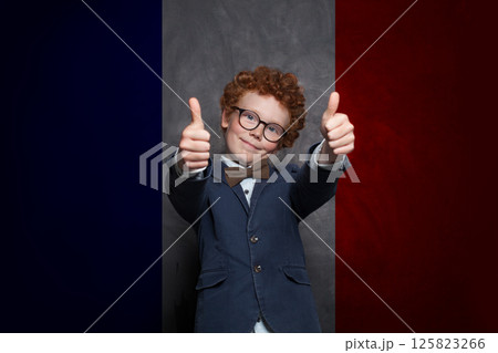 Redhead child boy on French flag background. Education, travel, school, camp and study language Redhead child boy on French flag background. Education, travel, school, camp and study language 125823266