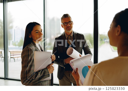 A Business Meeting where Professionals are Discussing Various Charts and Detailed Reports 125823330