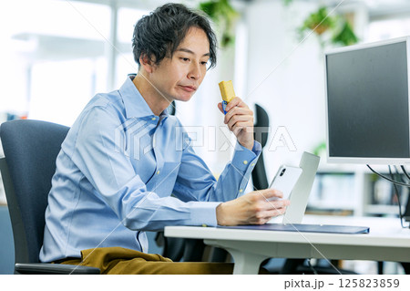 オフィスでプロテインバーを食べる男性 オフィスでプロテインバーを食べる男性 125823859