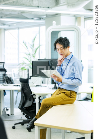 オフィスでタブレットを操作するビジネスマン 125823866