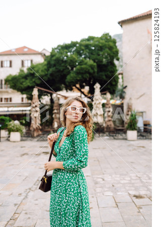 Happy female tourist in beautiful dress walking in the street of the city. Fashion style. Travel. Happy female tourist in beautiful dress walking in the street of the city. Fashion style. Travel. 125824193