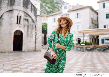Young woman in beautiful dress walking in the street of the city. Eurotrip. Travel, tourism. Fashion Young woman in beautiful dress walking in the street of the city. Eurotrip. Travel, tourism. Fashion 125824232