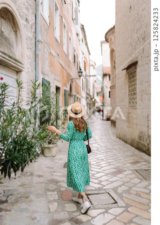 Young woman in beautiful dress walking in the street of the city. Eurotrip. Travel, tourism. Fashion Young woman in beautiful dress walking in the street of the city. Eurotrip. Travel, tourism. Fashion 125824233