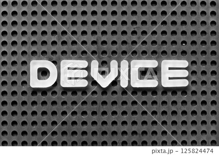 White alphabet letter in word device on black pegboard background 125824474