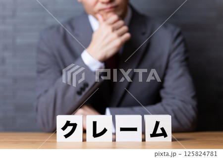 クレームのブロックとスーツを着て悩むミドル男性ビジネスマン クレームのブロックとスーツを着て悩むミドル男性ビジネスマン 125824781
