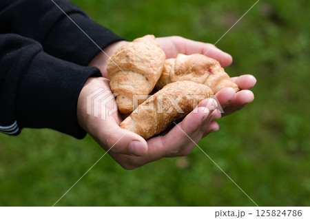 Hands holding fresh pastries outdoors Hands holding fresh pastries outdoors 125824786