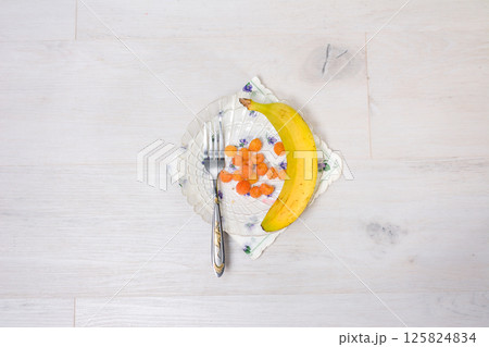 Banana and berries on a plate with a fork. 125824834