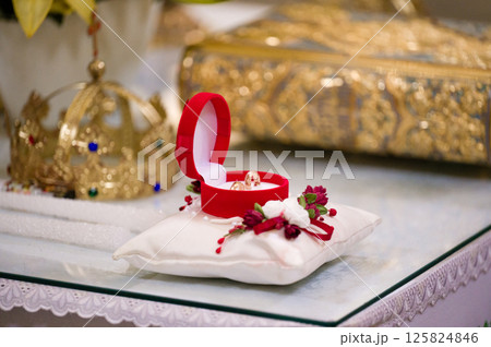 Wedding rings in a red box on a white pillow, ready for the ceremony. 125824846