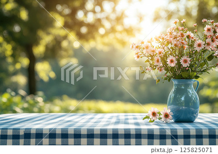 Picnic table with checkered tablecloth and a vase with flowers on a summer background. Retro-style. Mockup. Copy space. Picnic table with checkered tablecloth and a vase with flowers on a summer background. Retro-style. Mockup. Copy space. 125825071