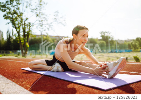 Young woman in sports outfit doing exercises outdoors in morning. Sport, Active life sports training Young woman in sports outfit doing exercises outdoors in morning. Sport, Active life sports training 125826023