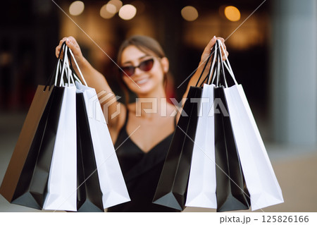 Shopping bags in the hands. Fashion woman with packages after shopping. Black friday, sale. Shopping bags in the hands. Fashion woman with packages after shopping. Black friday, sale. 125826166