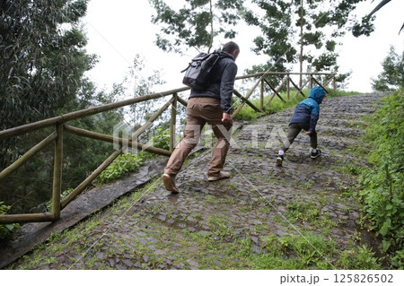Father and son hiking up steep cobblestone path in nature Father and son hiking up steep cobblestone path in nature 125826502