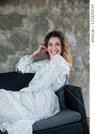 woman in summer white dress smiling on gray background 125826934