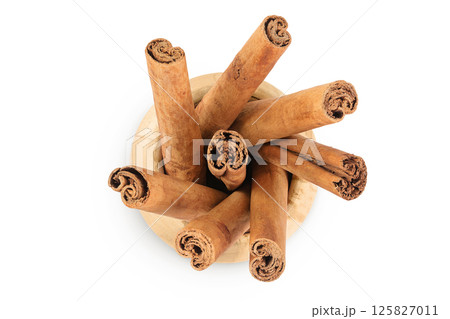 Cinnamon sticks in wooden bowl isolated on white background with full depth of field. Top view. Flat lay. 125827011